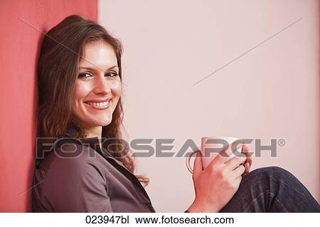 Stock Image - young businesswoman having break drinking coffee. Fotosearch