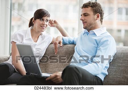 young couple at home sitting in front of laptop computer View Large Photo Image Stock Image - young couple at home sitting in front of laptop computer. Fotosearch