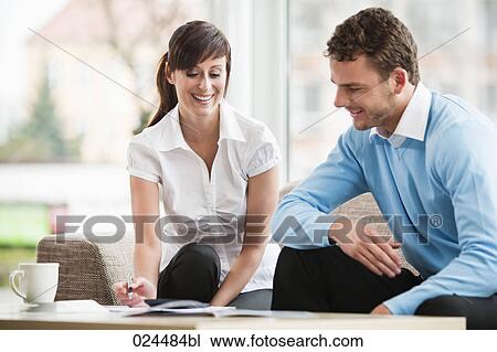 Stock Image - young couple at home talking about document. Fotosearch