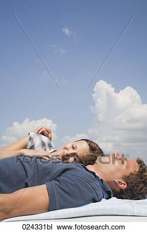 young couple lying on roof of car View Large Photo Image Stock Image - young couple lying on roof of car. Fotosearch