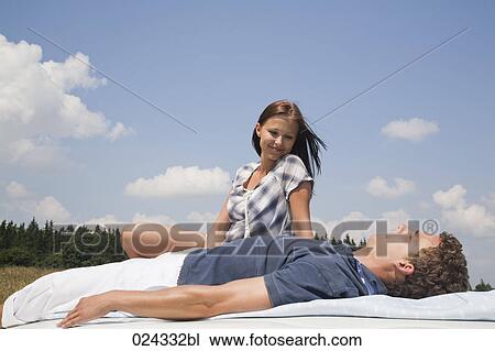 young couple lying on roof of car View Large Photo Image Stock Image - young couple lying on roof of car. Fotosearch