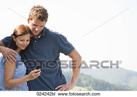 young couple reading message on mobile phone View Large Photo Image Stock Image - young couple reading message on mobile phone. Fotosearch
