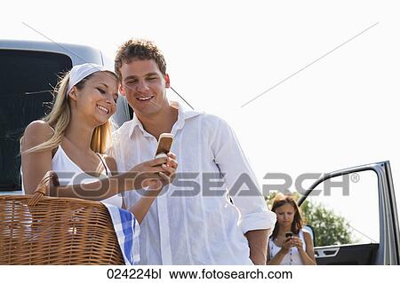 Stock Image - young couple reading text message on mobile phone together. Fotosearch