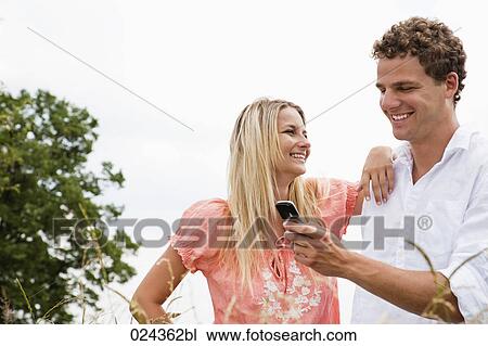 young couple reading text message on mobile phone View Large Photo Image Stock Image - young couple reading text message on mobile phone. Fotosearch