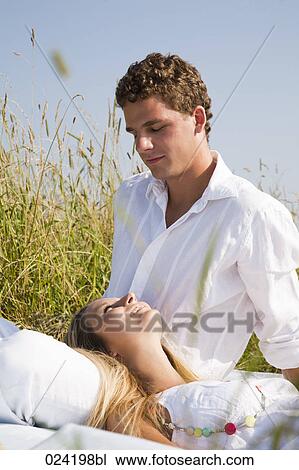 young couple relaxing in meadow View Large Photo Image Stock Image - young couple relaxing in meadow. Fotosearch