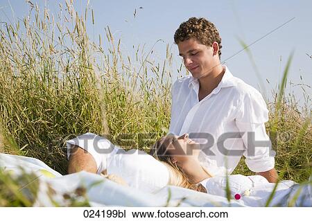 Stock Image - young couple relaxing in meadow. Fotosearch