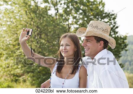 Stock Image - young couple taking picture of themselves. Fotosearch