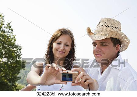 Stock Image - young couple taking picture of themselves. Fotosearch