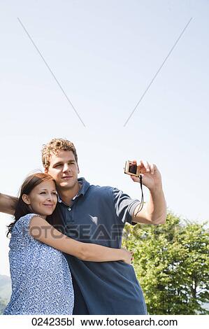 young couple taking picture of themselves with digital camera View Large Photo Image Stock Image - young couple taking picture of themselves with digital camera. Fotosearch