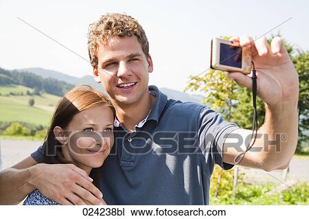 young couple taking picture of themselves with digital camera View Large Photo Image Stock Image - young couple taking picture of themselves with digital camera. Fotosearch