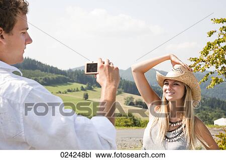 young man taking portrait of girlfriend with digital camera View Large Photo Image Stock Image - young man taking portrait of girlfriend with digital camera. Fotosearch