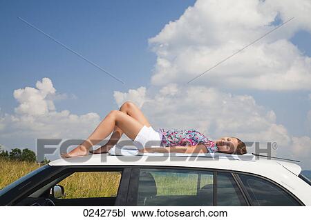 young woman dozing on roof of car View Large Photo Image Stock Image - young woman dozing on roof of car. Fotosearch