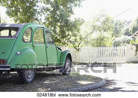 Stock Image - citroen 2cv car standing in shadow of a tree. Fotosearch