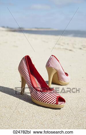 Stock Image - high heels shoes on sandy beach. Fotosearch
