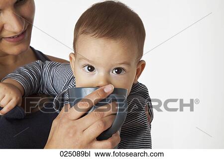 Stock Image - portrait of baby drinking from cup. Fotosearch
