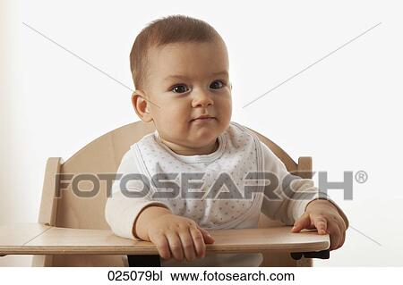 Stock Image - portrait of baby in high chair. Fotosearch