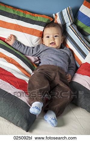 Stock Image - portrait of baby lying in bed. Fotosearch