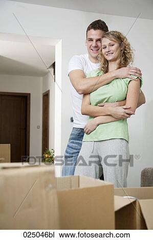 Stock Image - portrait of young couple in new home. Fotosearch