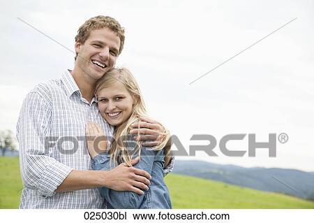 portrait of young couple on meadow View Large Photo Image Stock Image - portrait of young couple on meadow. Fotosearch