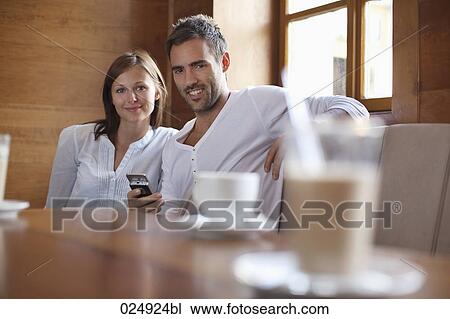 portrait of young couple sitting at cafe View Large Photo Image Stock Image - portrait of young couple sitting at cafe. Fotosearch