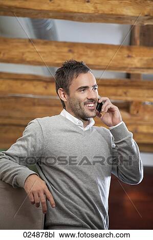 Stock Image - portrait of young man talking on mobile phone. Fotosearch