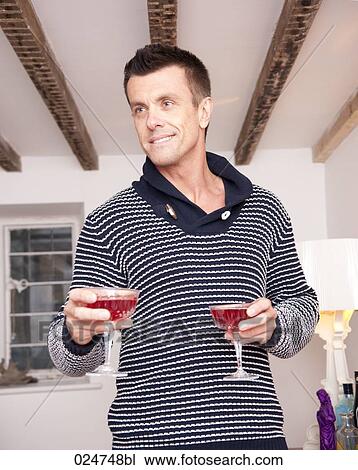 Stock Image - portrait of young man with two glasses of champagne. Fotosearch