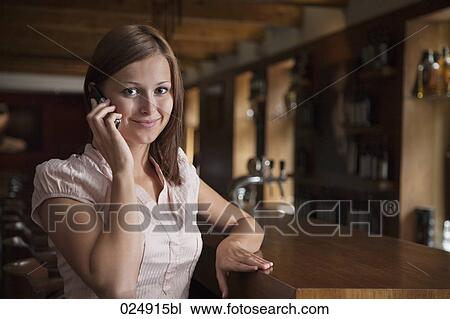 portrait of young woman at bar talking on mobile phone View Large Photo Image Stock Image - portrait of young woman at bar talking on mobile phone. Fotosearch
