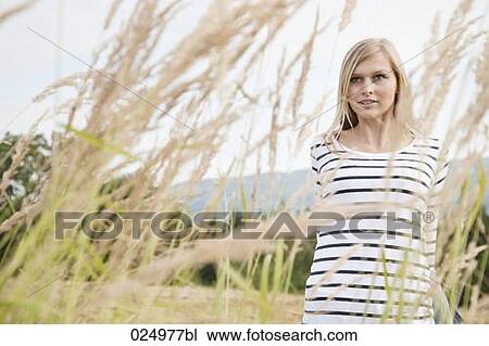 Stock Image - portrait of young woman behind reeds. Fotosearch