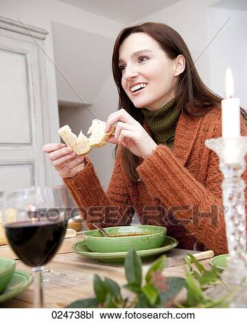 Stock Image - portrait of young woman eating bread. Fotosearch