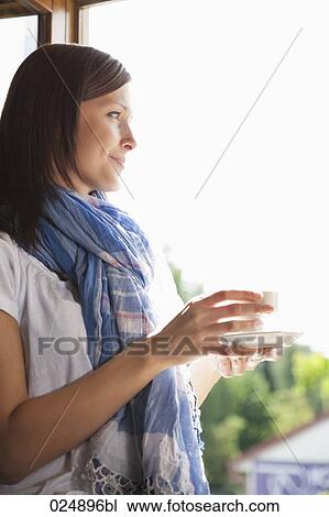 portrait of young woman having cup of coffee at window View Large Photo Image Stock Image - portrait of young woman having cup of coffee at window. Fotosearch