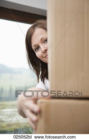 portrait of young woman hiding behind cardboard boxes View Large Photo Image Stock Image - portrait of young woman hiding behind cardboard boxes. Fotosearch