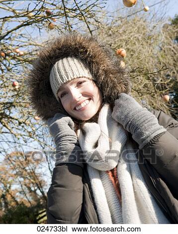 Stock Image - portrait of young woman outdoors wearing warm winter close. Fotosearch