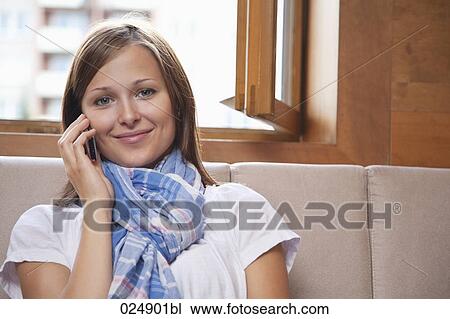 portrait of young woman sitting by window talking on mobile phone View Large Photo Image Stock Image - portrait of young woman sitting by window talking on mobile phone. Fotosearch