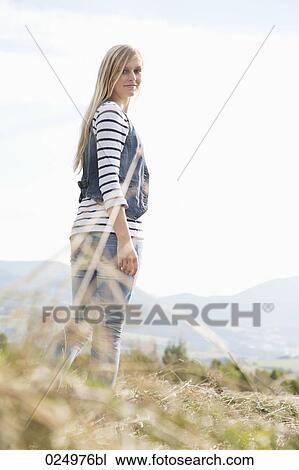 portrait of young woman standing in field View Large Photo Image Stock Image - portrait of young woman standing in field. Fotosearch