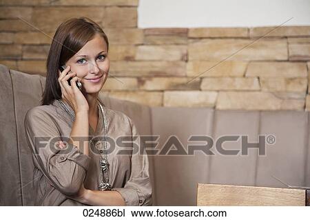 portrait of young woman talking on mobile phone at restaurant View Large Photo Image Stock Image - portrait of young woman talking on mobile phone at restaurant. Fotosearch