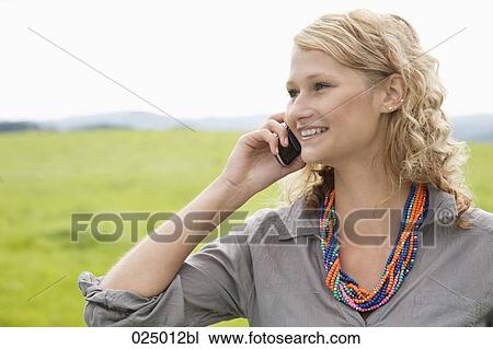 Stock Image - portrait of young woman talking on mobile phone. Fotosearch
