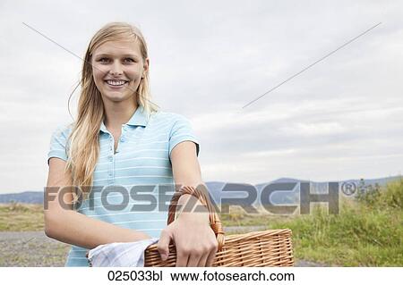 Stock Image - portrait of young woman with basket. Fotosearch