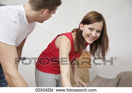 Stock Image - portraitof young woman while moving home. Fotosearch