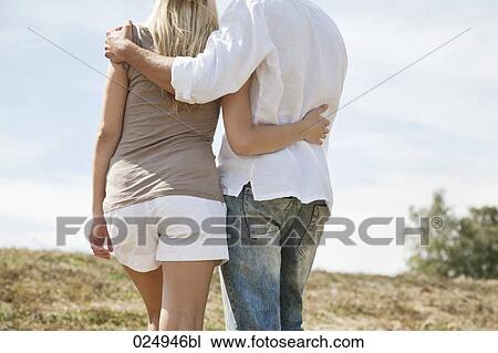 rear view of young couple standing in field View Large Photo Image Stock Image - rear view of young couple standing in field. Fotosearch
