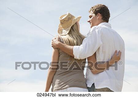 rear view of young couple standing in embrace View Large Photo Image Stock Image - rear view of young couple standing in embrace. Fotosearch