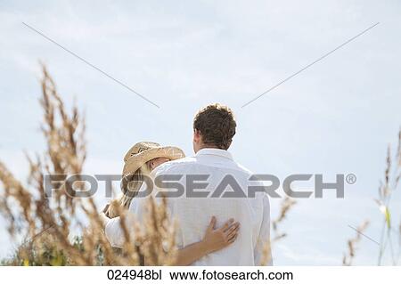 rear view of young couple standing in embrace View Large Photo Image Stock Image - rear view of young couple standing in embrace. Fotosearch
