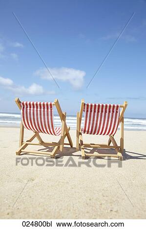 Stock Image - two sun loungers on sandy beach. Fotosearch