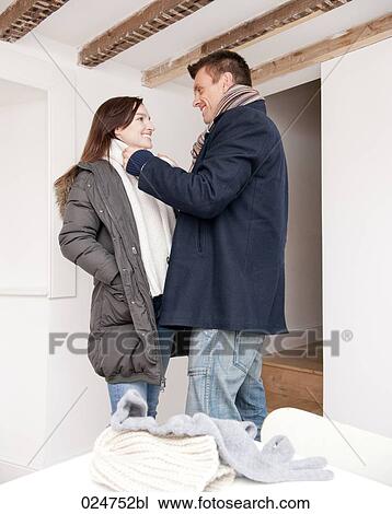 Stock Image - young couple dressing up in winter clothes. Fotosearch