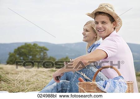 young couple having picnic in field View Large Photo Image Stock Image - young couple having picnic in field. Fotosearch