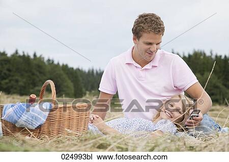 young couple in field man looking at display of mobile phone View Large Photo Image Stock Image - young couple in field man looking at display of mobile phone. Fotosearch
