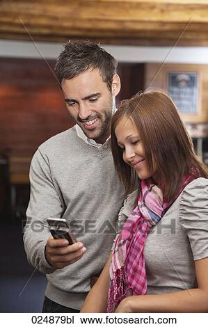 young couple looking at display of mobile phone View Large Photo Image Stock Image - young couple looking at display of mobile phone. Fotosearch