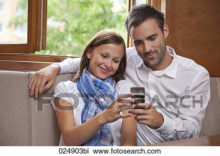young couple looking at display of mobile phone View Large Photo Image Stock Image - young couple looking at display of mobile phone. Fotosearch