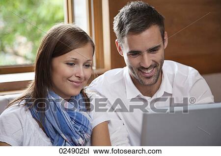 young couple looking at laptop computer View Large Photo Image Stock Image - young couple looking at laptop computer. Fotosearch