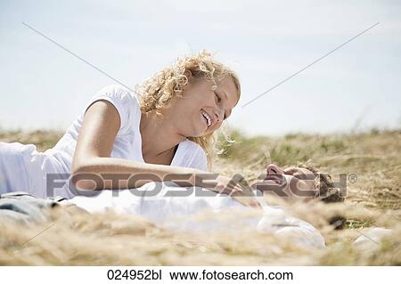 Stock Image - young couple lying in field in summer. Fotosearch