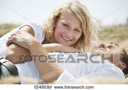 Stock Image - young couple lying in field in summer. Fotosearch